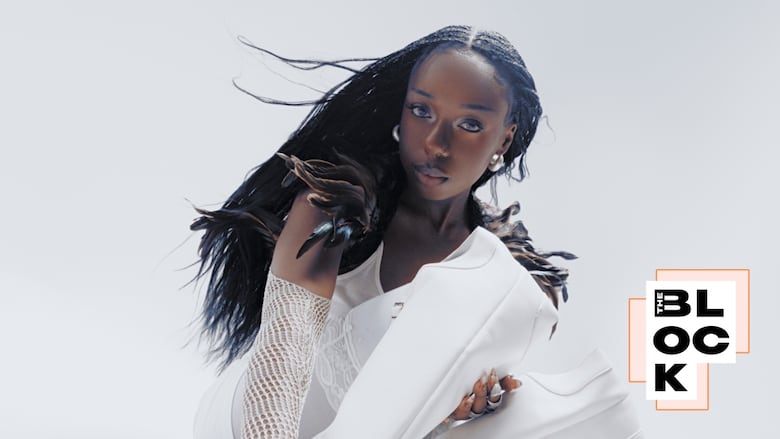 debby friday wears all white and silver jewellery, her hair is in dark box braids.