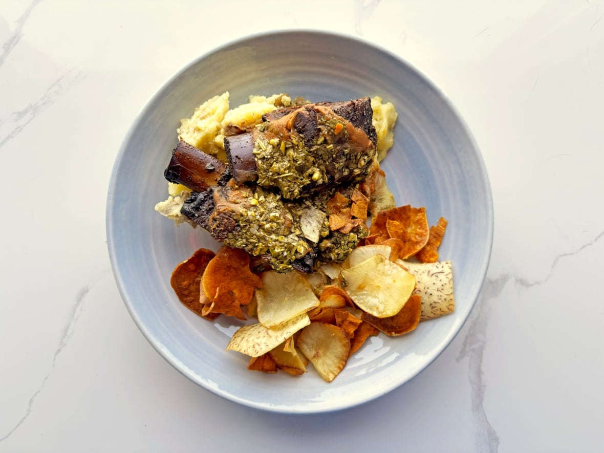 Smoked bison ribs on a bed of garlic mashed potatoes and veggie chips.