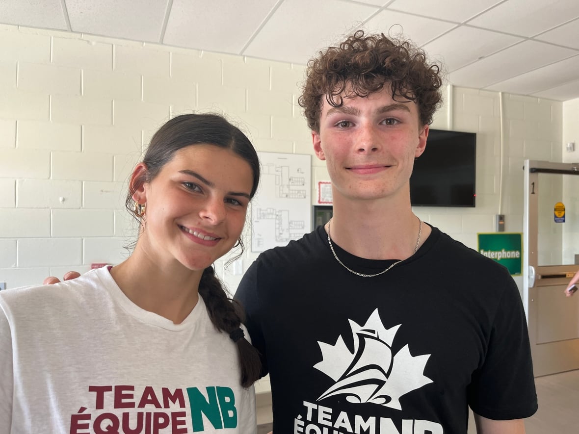 A woman and a man in tee shirts pose for a photo
