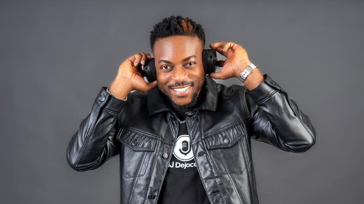 A photo of JJ Okonkwo wearing headphones and smiling.
