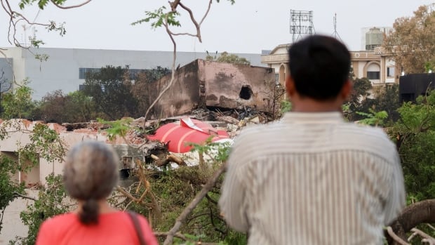People are seen looking at wreckage from a June 2025 Air India crash that occurred shortly after takeoff in Ahmedabad, India.