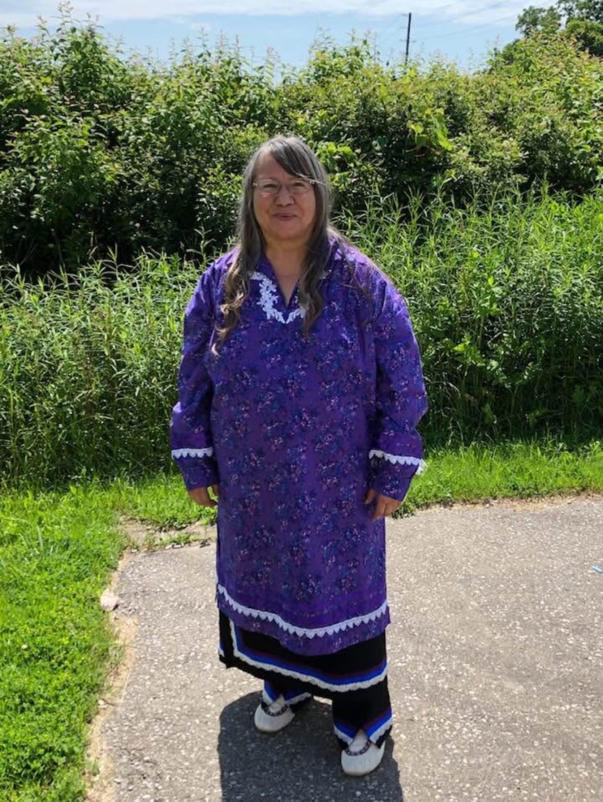 Woman standing in traditional Haudenosaunee dress.