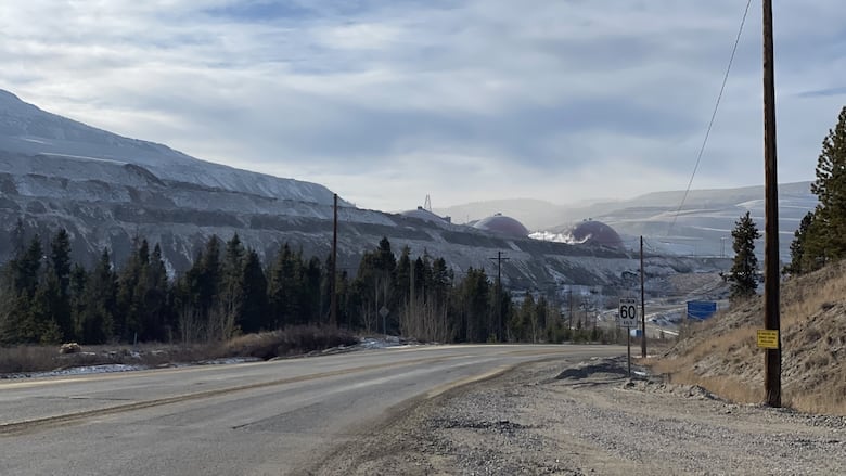 A long road leads buildings in the distance.