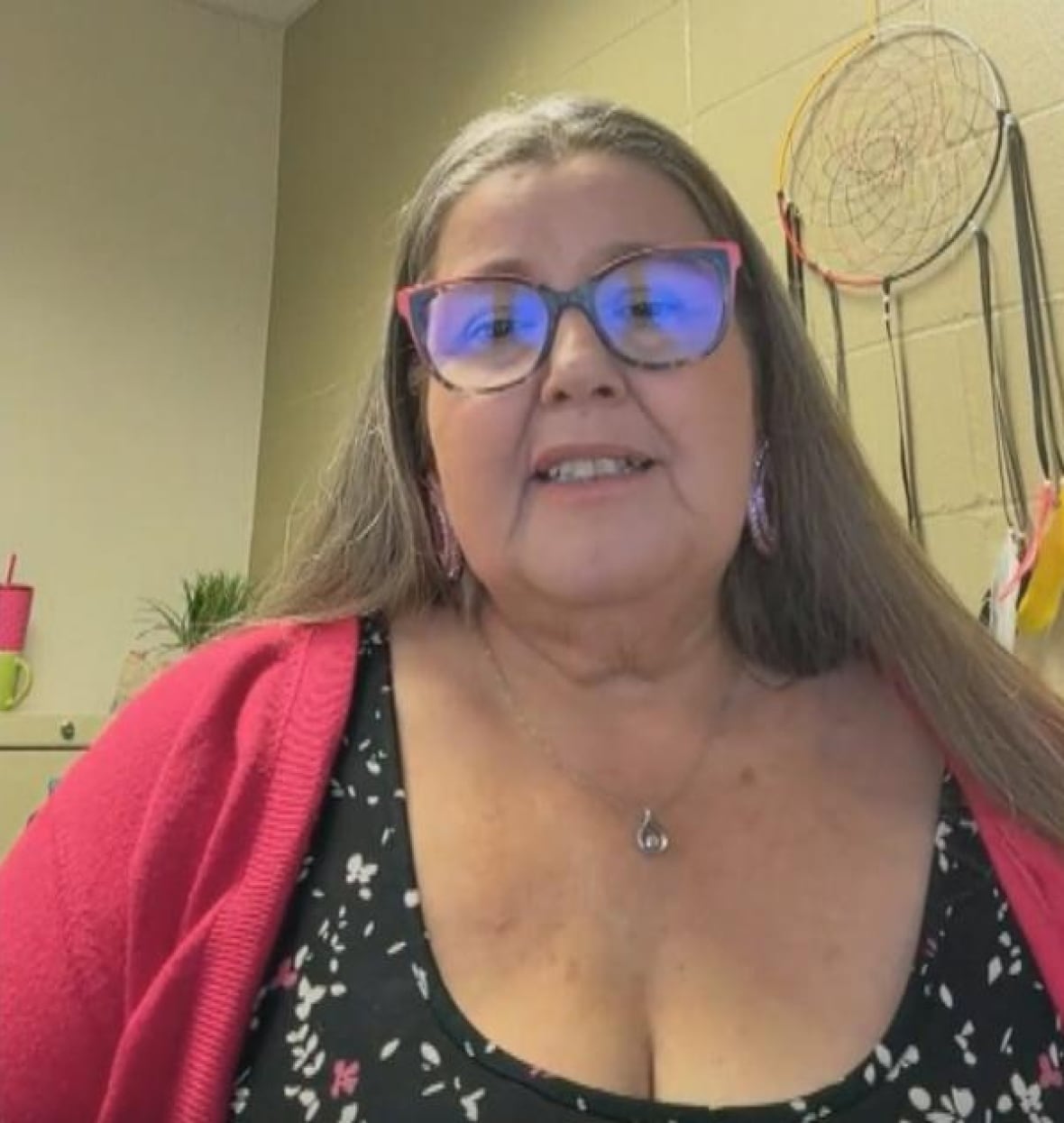 woman with long grey hair and bead earrings