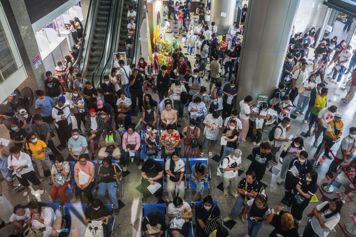 The upper view shows dozens of people sitting and standing in an internal area.