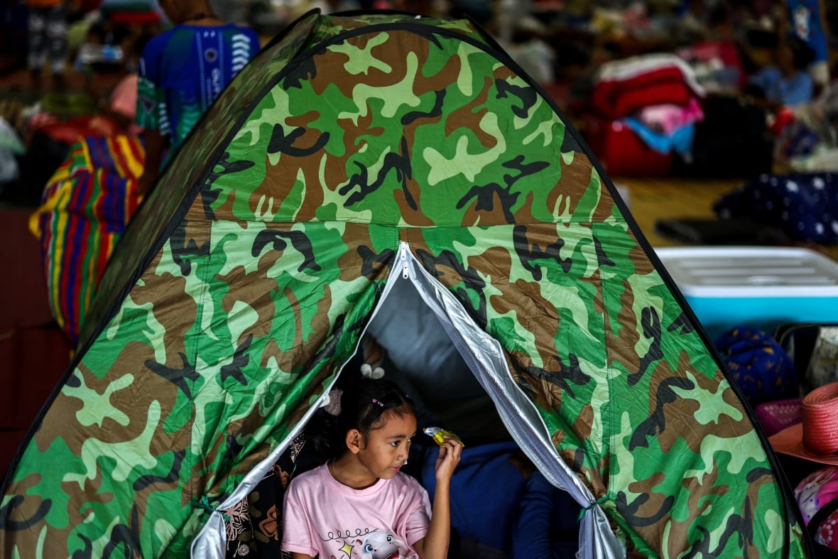 A little girl appears inside a hut -like structure.