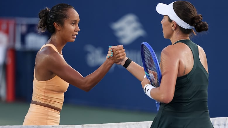 Two women tennis players shake hands.