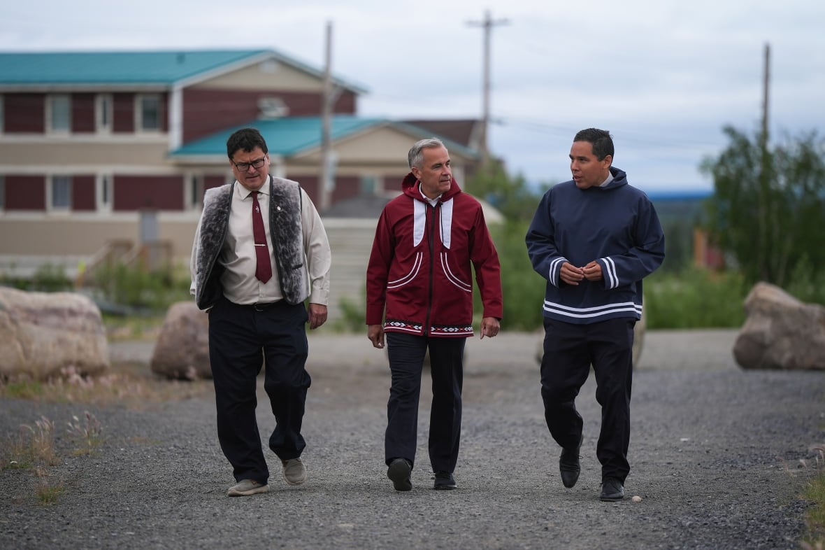 Prime Minister Mark Carney walks with Duane Smith, left, chair and CEO of the Inuvialuit Regional Corporation, and Natan Obed, right, president of the Inuit Tapiriit Kanatami, to a meeting of the Inuit-Crown Partnership Committee in Inuvik, N.W.T., on Thursday, July 24, 2025. THE CANADIAN PRESS/Darryl Dyck
