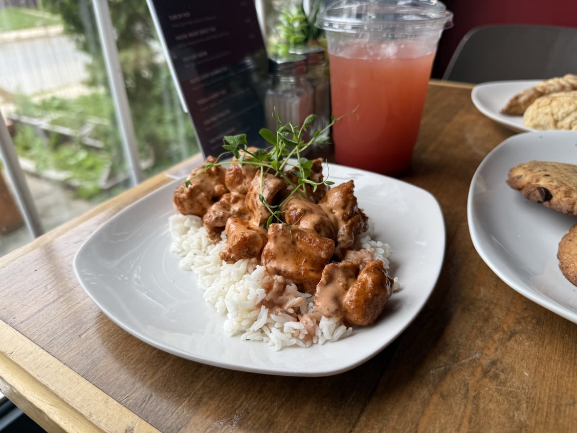 A plate of chicken sits on a table, with a garnish sprinkled atop it.