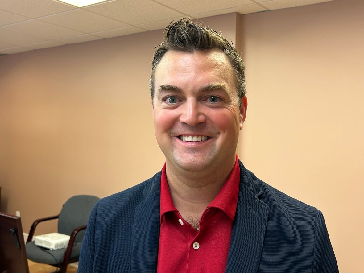 A white man with shiny brown spike styled hair.