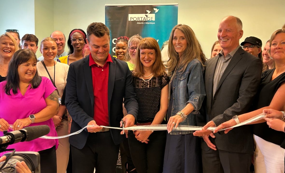 A bunch of people cutting a ribbon to inaugurate a youth drug rehabilitation centre.