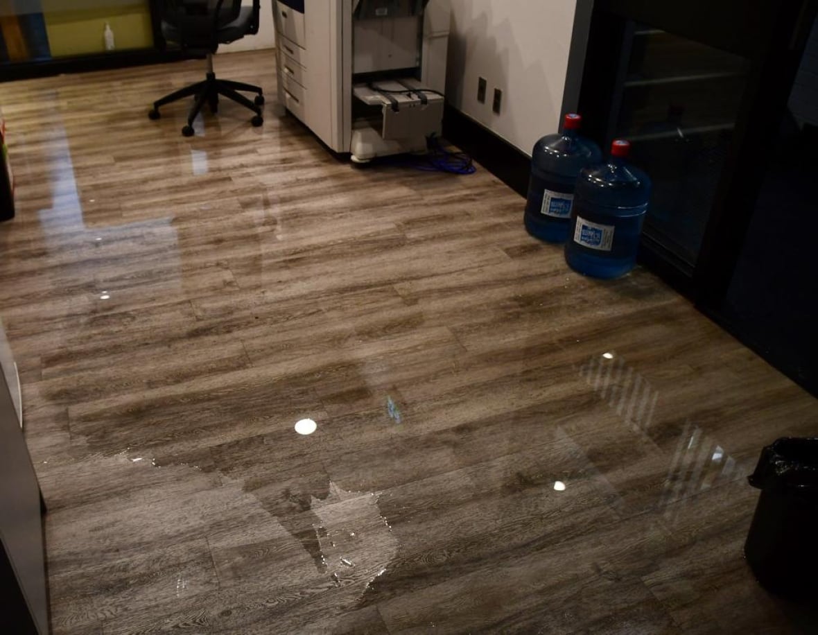 Water on the floor of an office in a Six Nations community building, with office furniture and supplies visible, following flooding in June 2025.