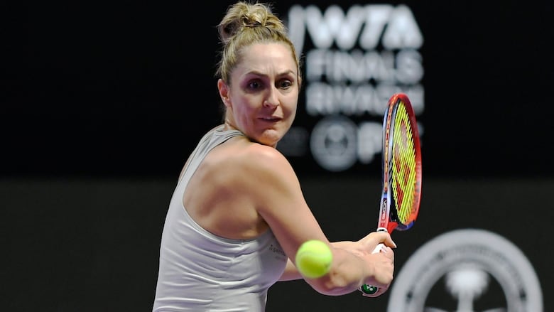A female tennis player returns a shot during a tennis match.
