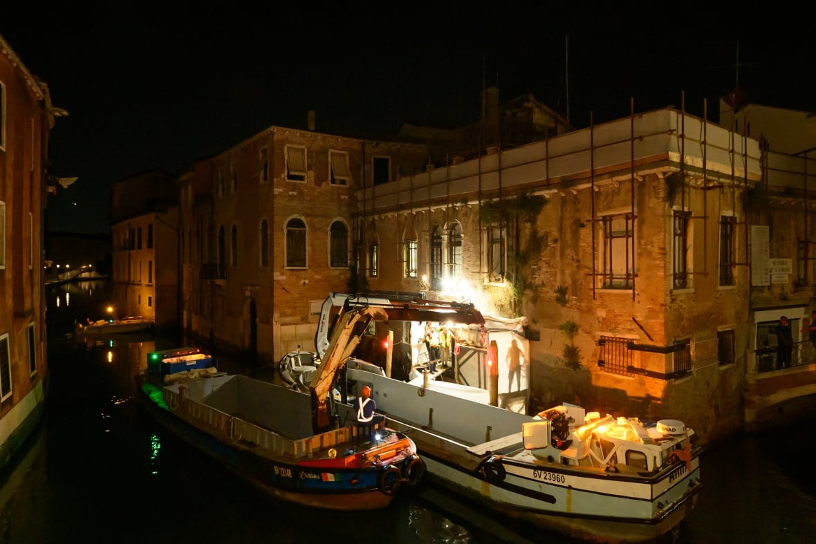 A view of an effort to remove a Banksy mural from the facade of a canal-side building in Venice, Italy.