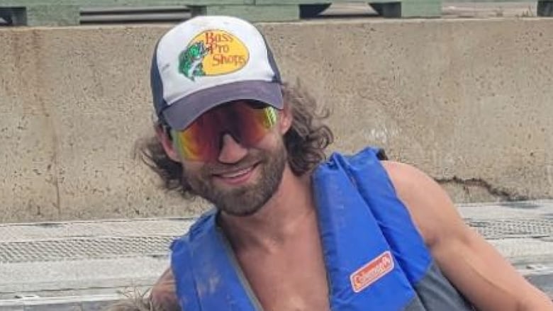 A man poses at a boat launch