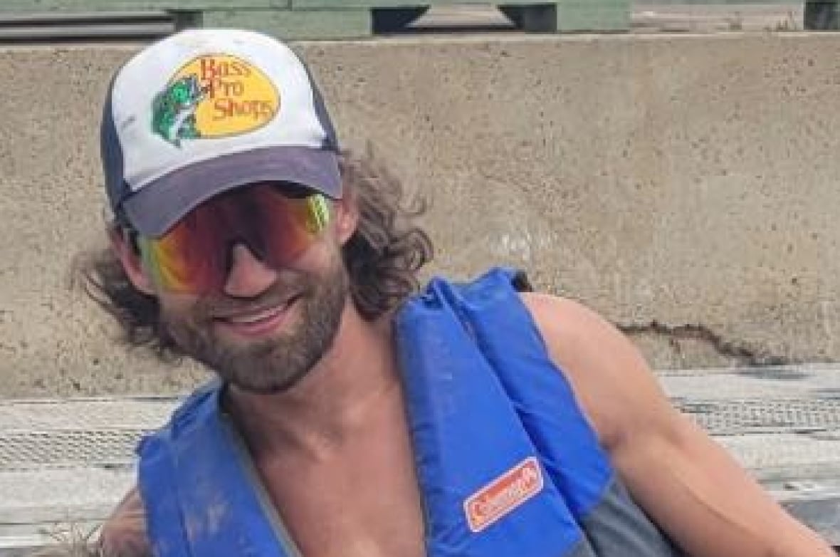 A man poses at a boat launch