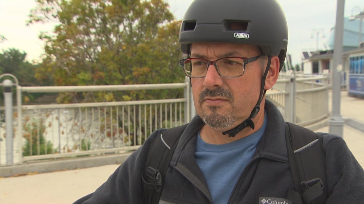 Man standing with e-scooter wearing a helmet