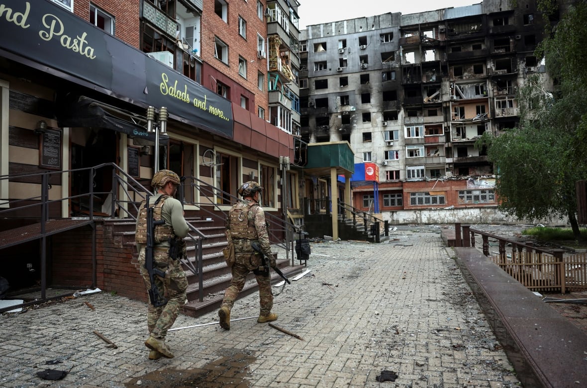 Members of a Ukrainian police unit who evacuate people from frontline towns and villages are seen walking in Pokrovsk, Ukraine.
