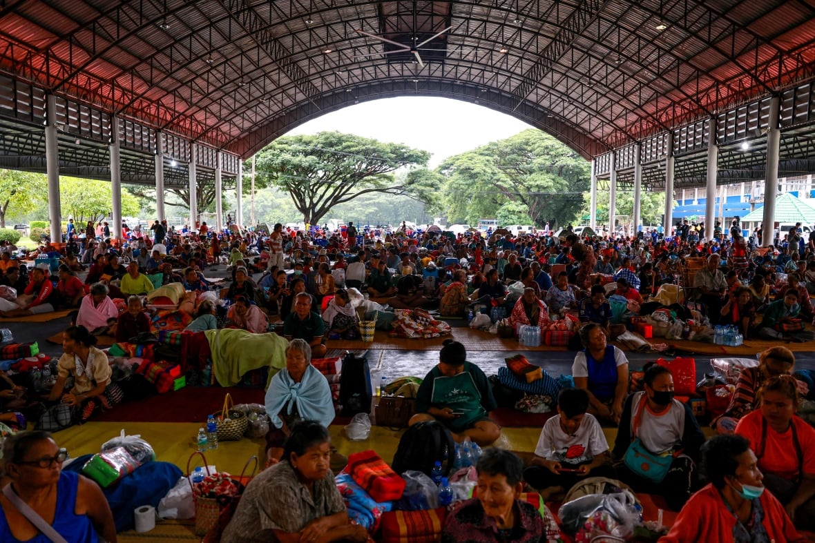 People rest inside the outer temporary accommodation.