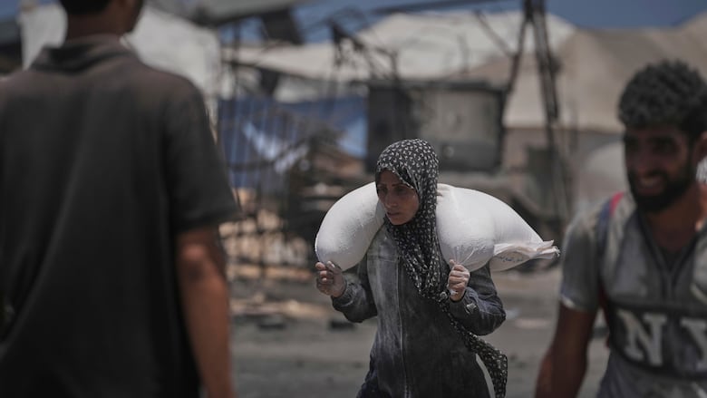 A person carries a sack of flour.