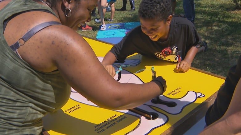 A mother and son play a giant game of Operation.