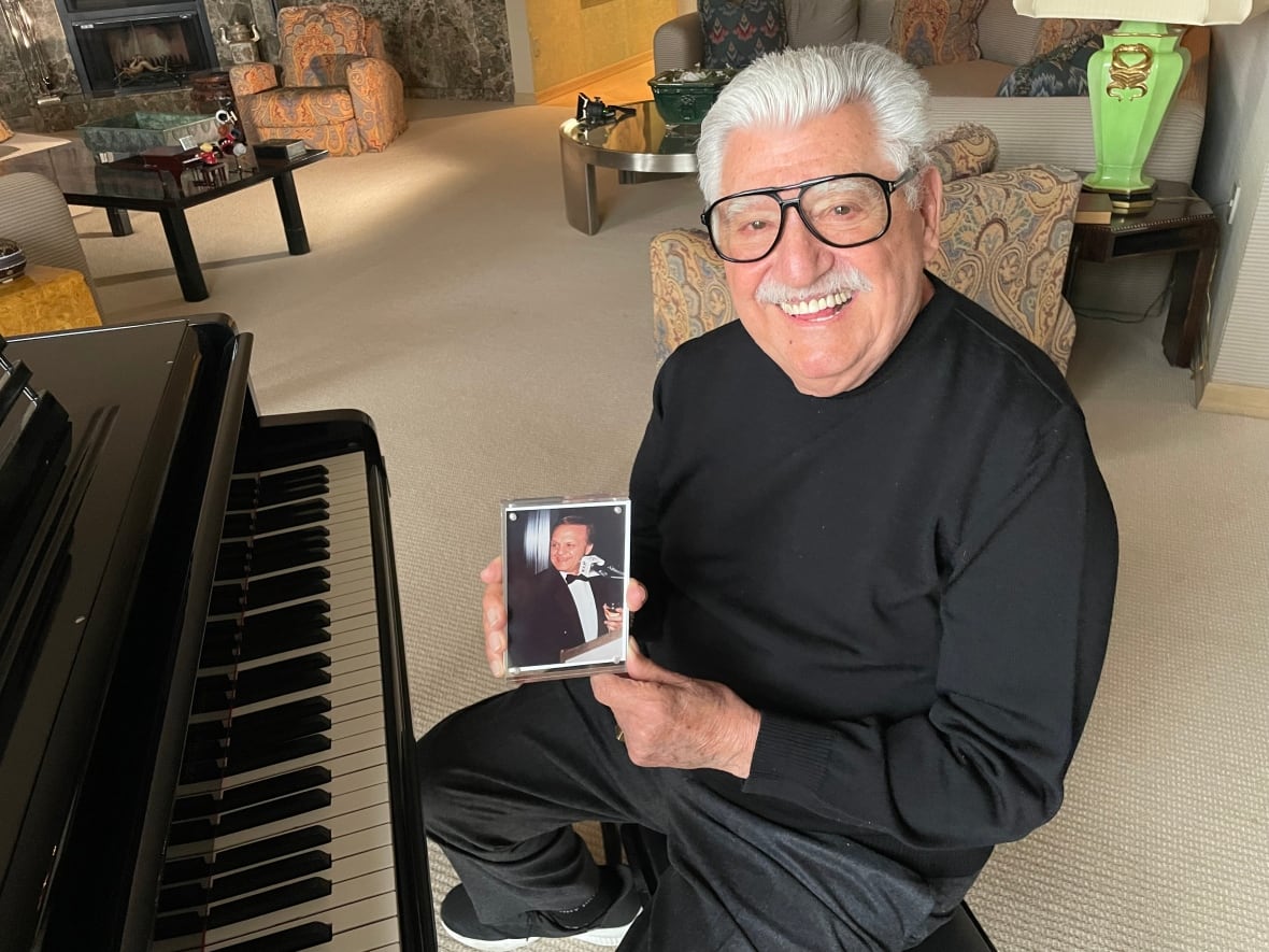 A man holds a photo of a man.
