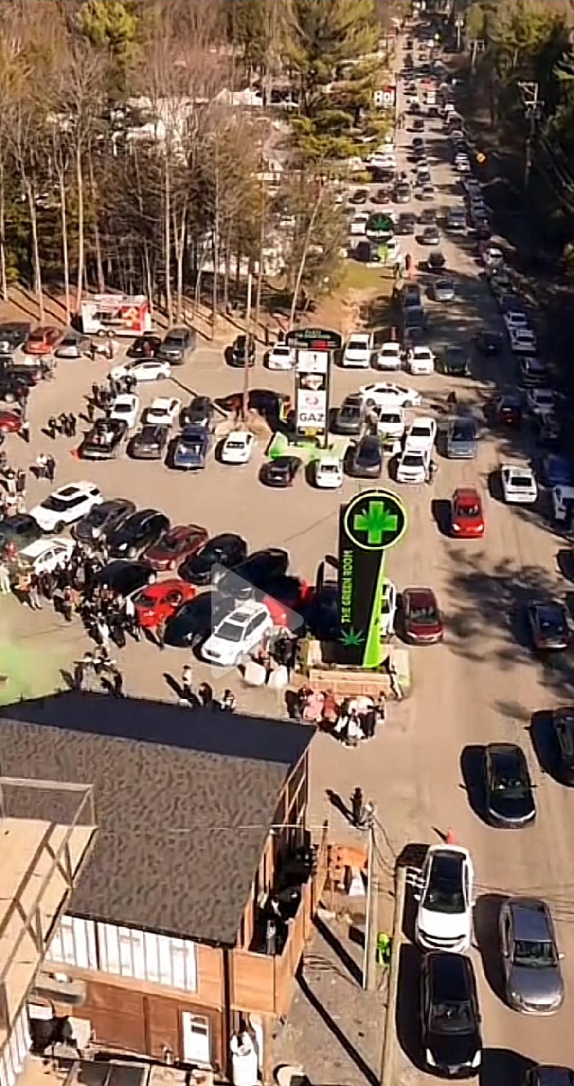 An aerial view of cars in a traffic jamp along a narrow highway next with a sign that says, The Green Room.