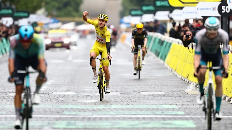A men's cyclist celebrates while riding.
