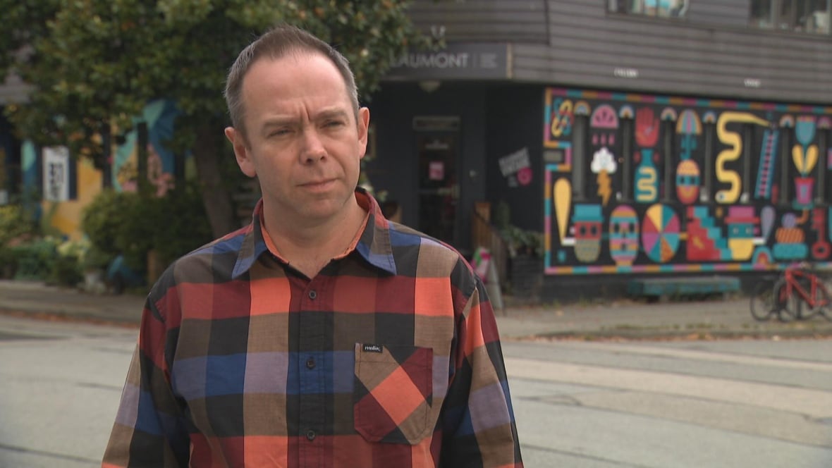 A man speaks in front of an artist studio space.