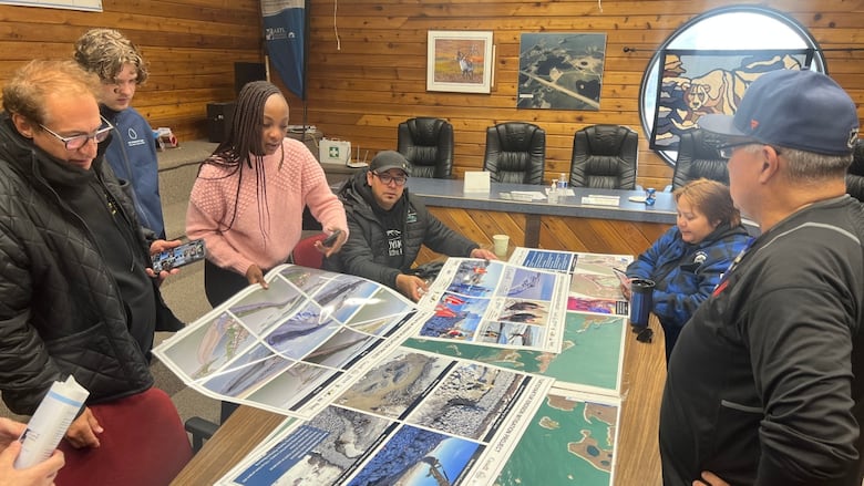 A group of people looking at images on a table
