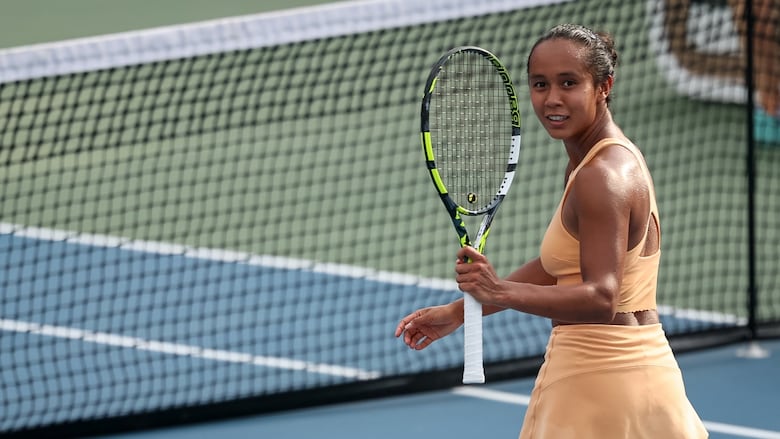 A women's tennis player reacts after winning a match.