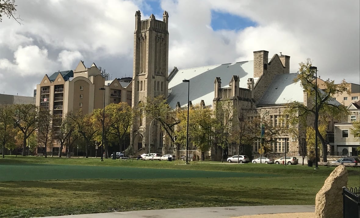 Exterior view of a large church with green space in front.