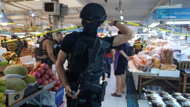 A policeman walks through a crime scene at a market.