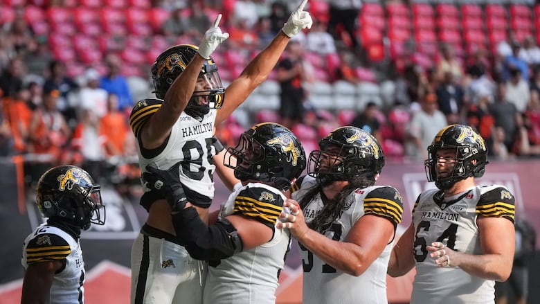 A group of people in football uniforms celebrating