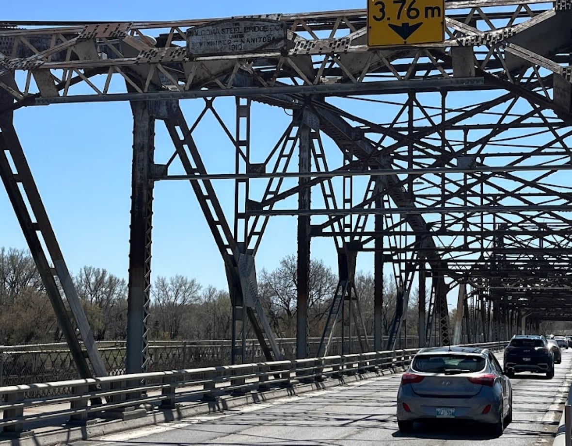 Close up of a sign on an old steel truss bridge