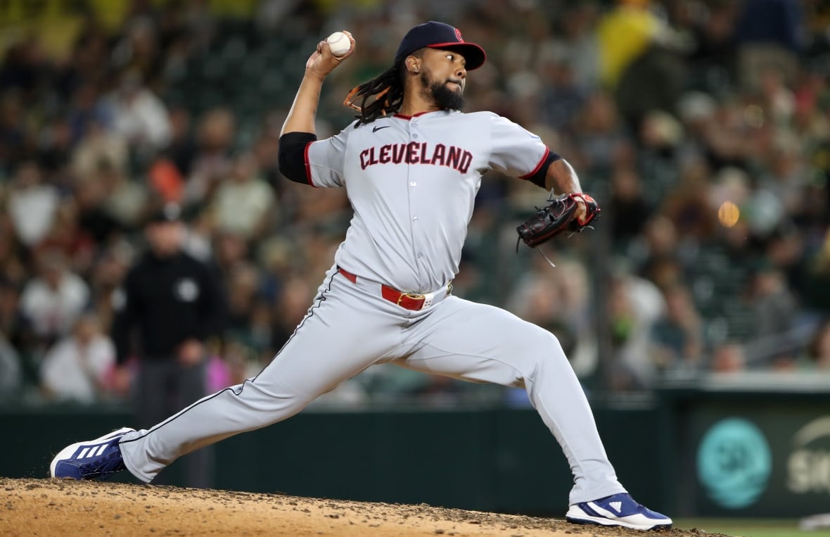 A men's pitcher is shown mid-delivery.