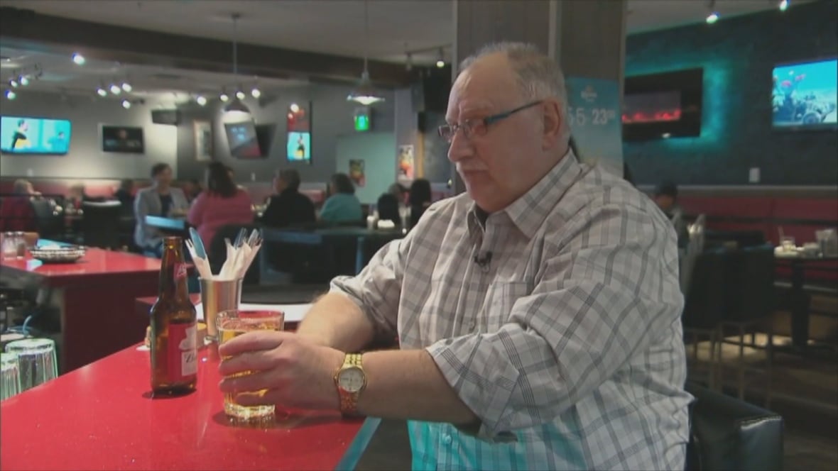 Man sits at bar with beer