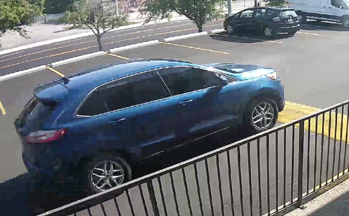 a cctv screen shot of a suv in a parking lot