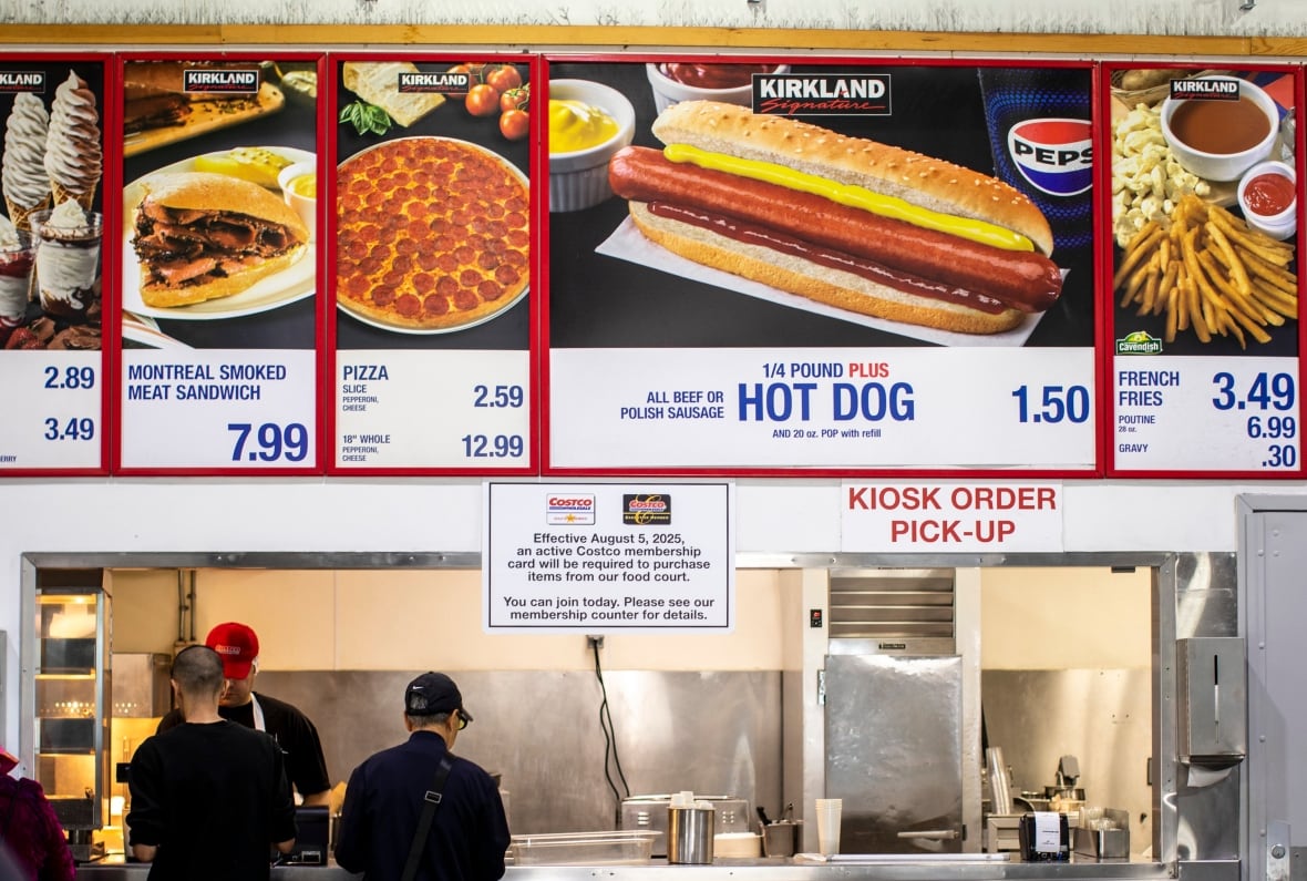 People stand in line at  a food court advertising $1.50 hot dogs