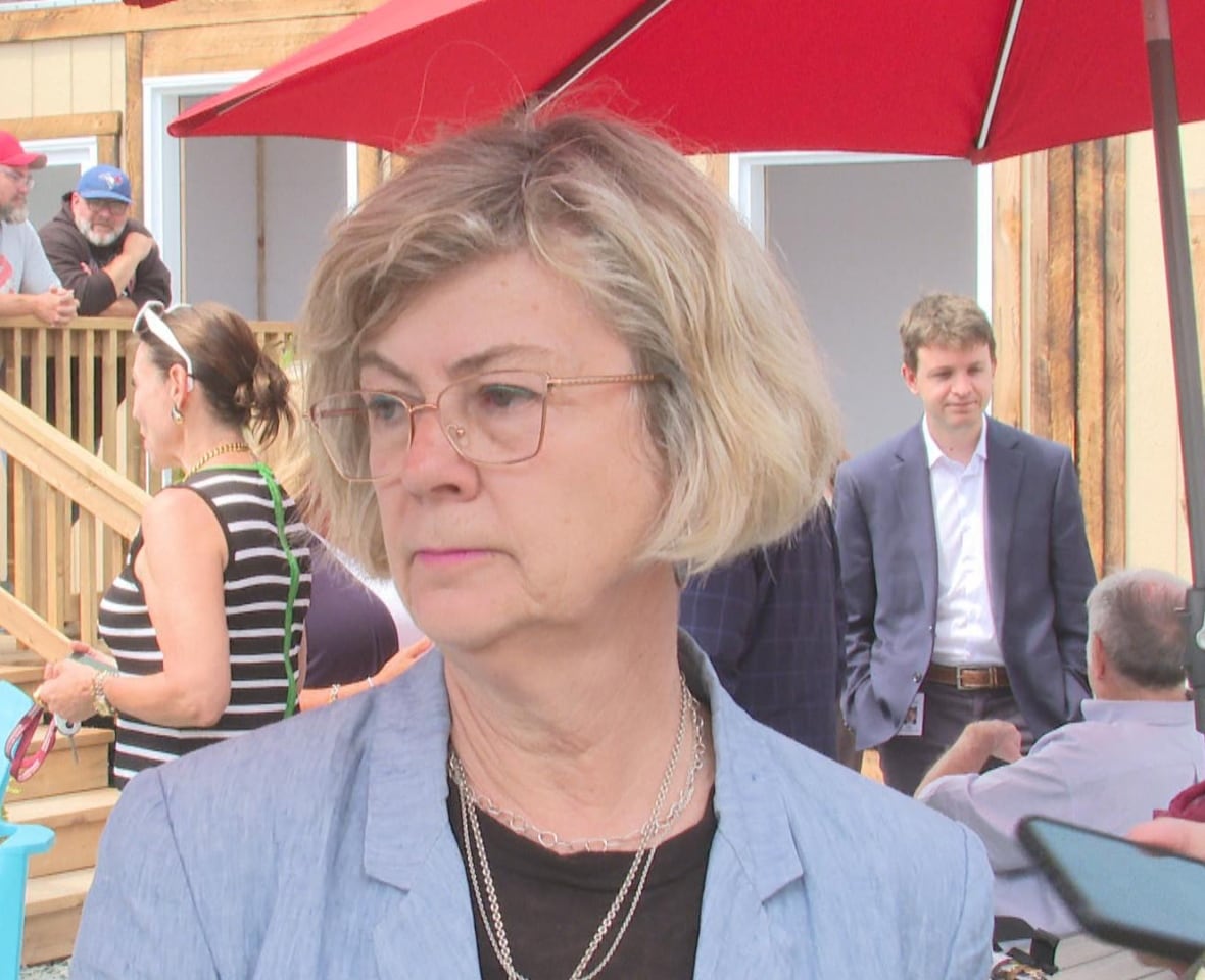 Woman looking off side camera with a neutral expression.