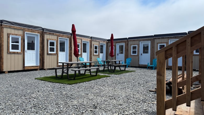 gravel court yard with picnic tables in the center surrounded by small bedroom sized homes. 