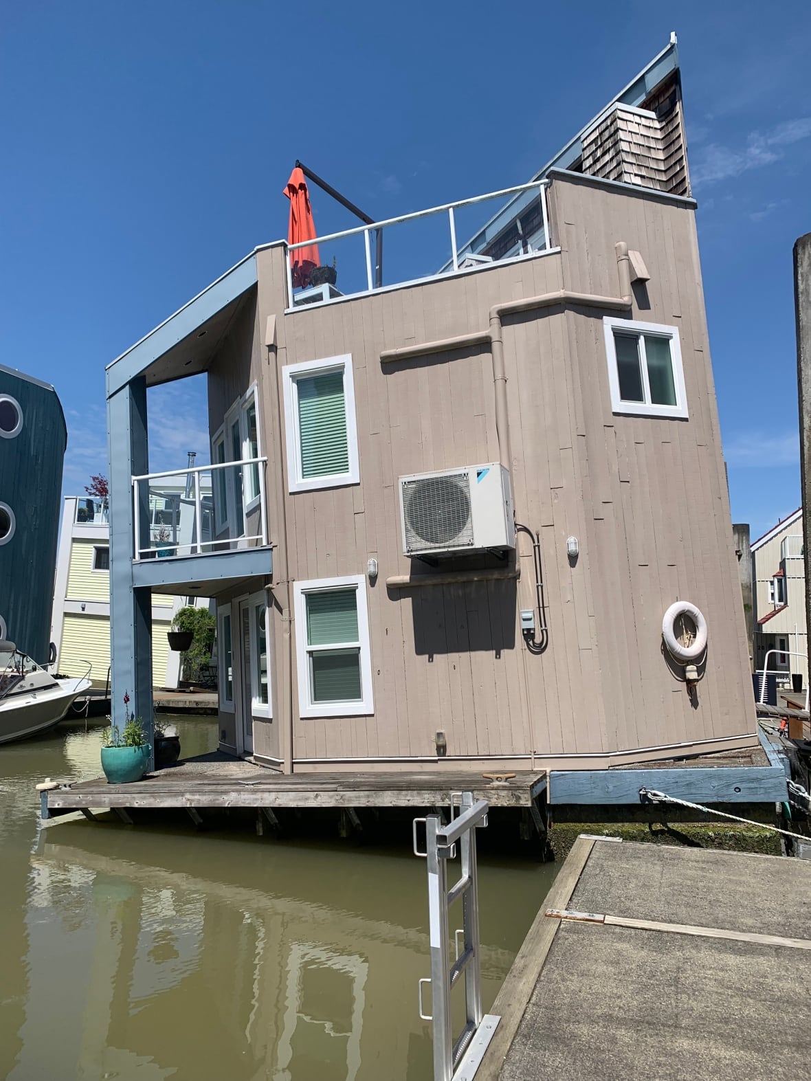 A beige float home is tilted