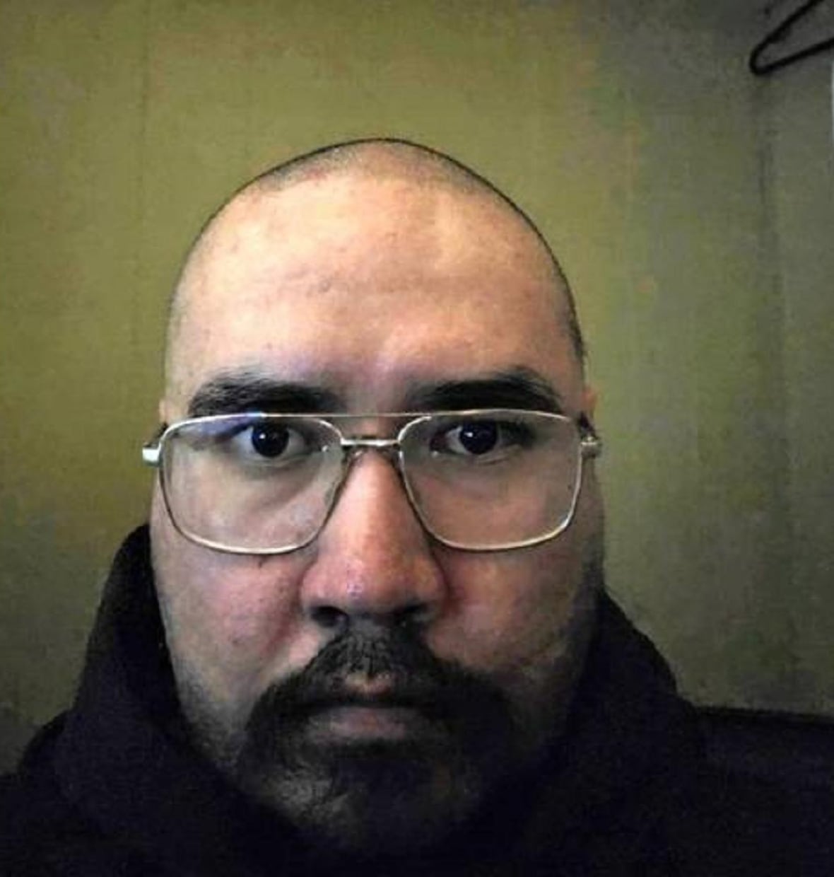 A portrait of a man in glasses with a shaved head.