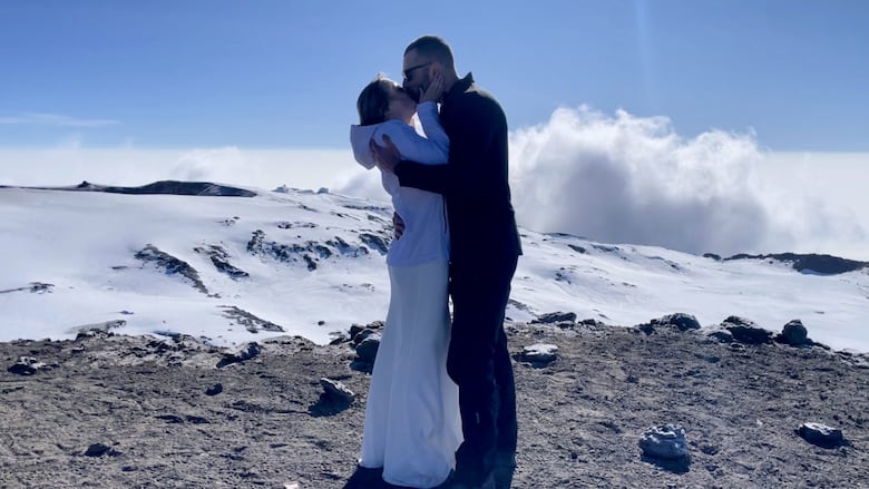 Kelsey Bone and Scot Pominville share a kiss as they stand on top of Mount Kilmanjaro after their ceremony.