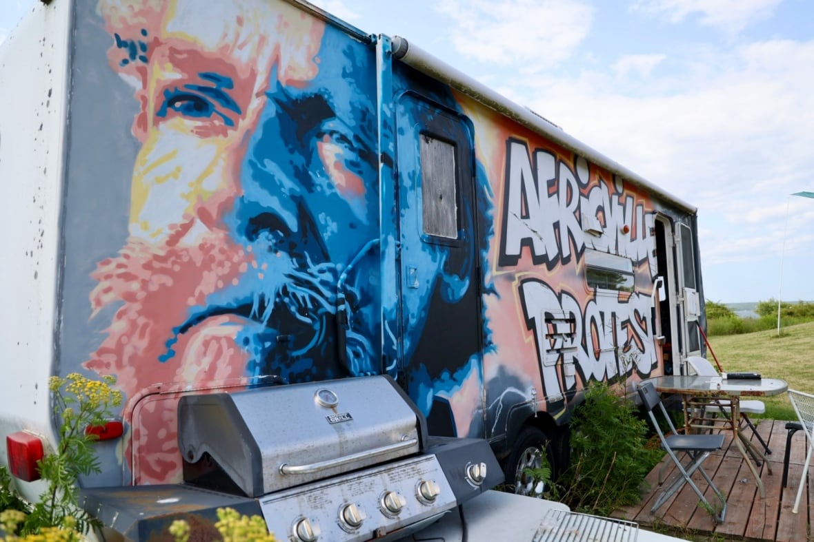 A trailer painted in graffiti with a man's portrait and the phrase "Africville protest."