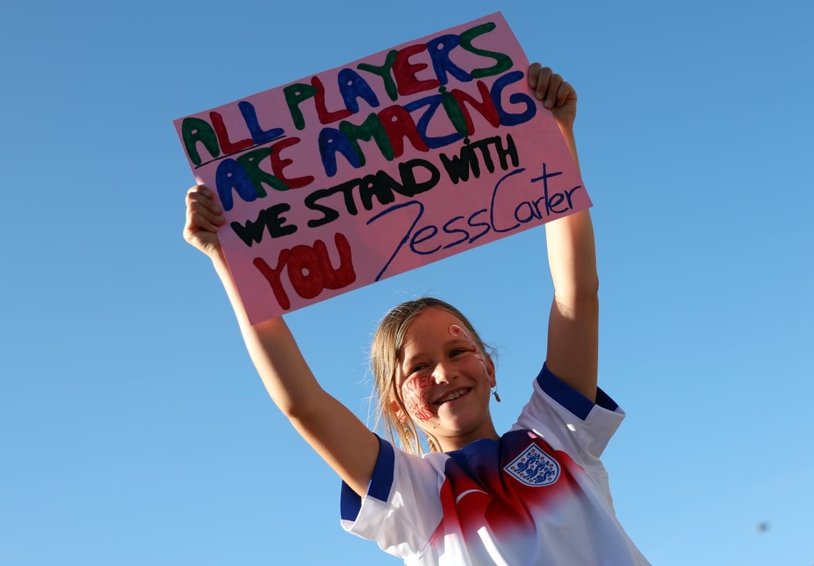 A girl holds up a sign.