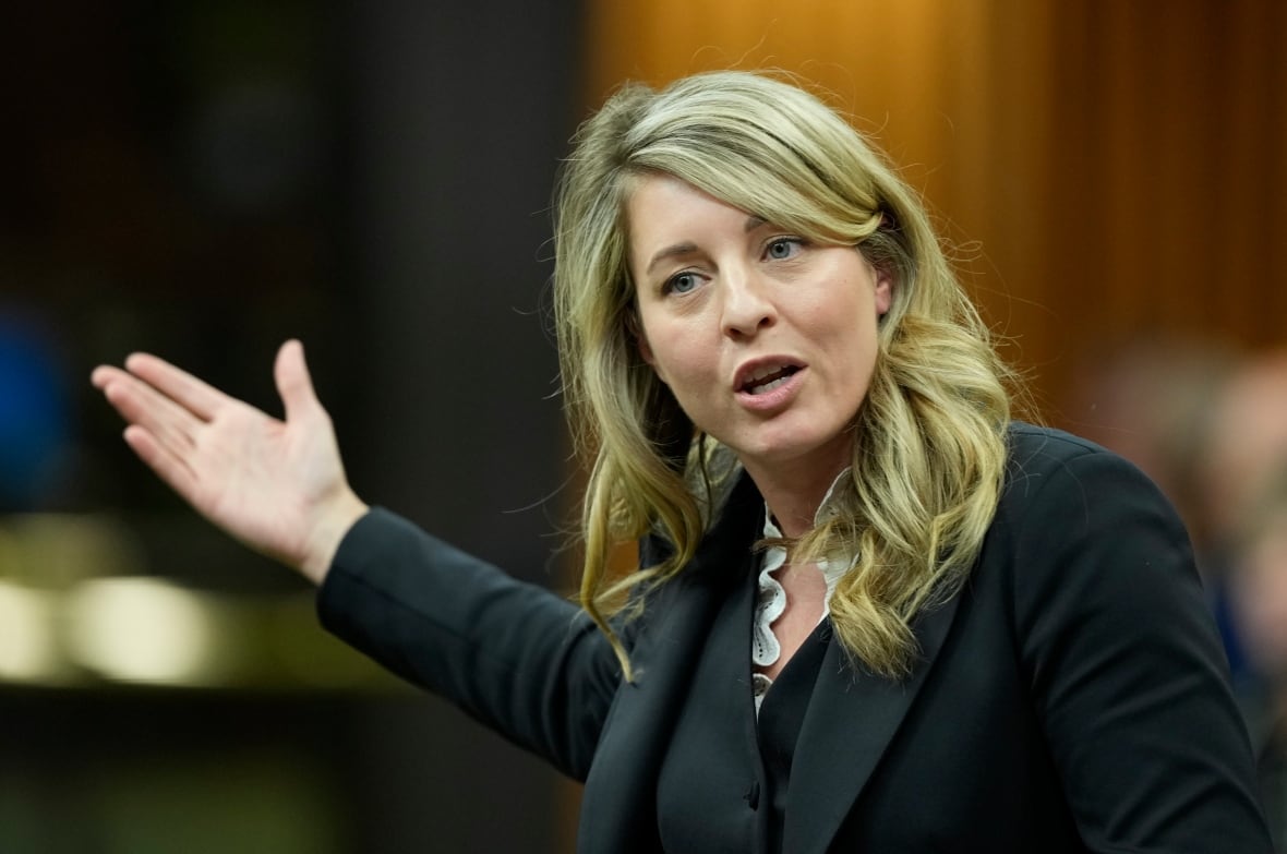 A woman gestures while speaking.