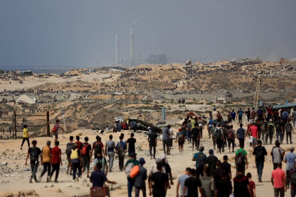 Crowds of people gather along a road.