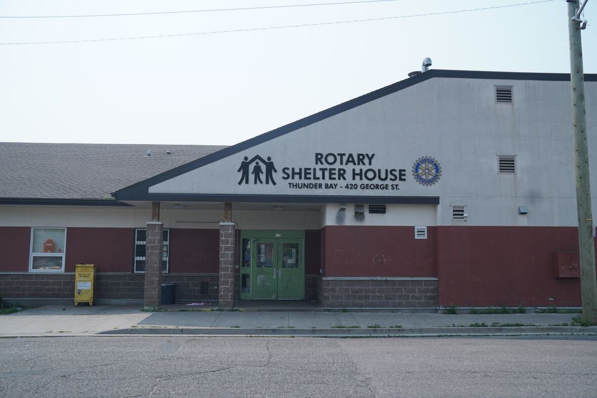 a white and red building displaying the words Rotary Shelter House