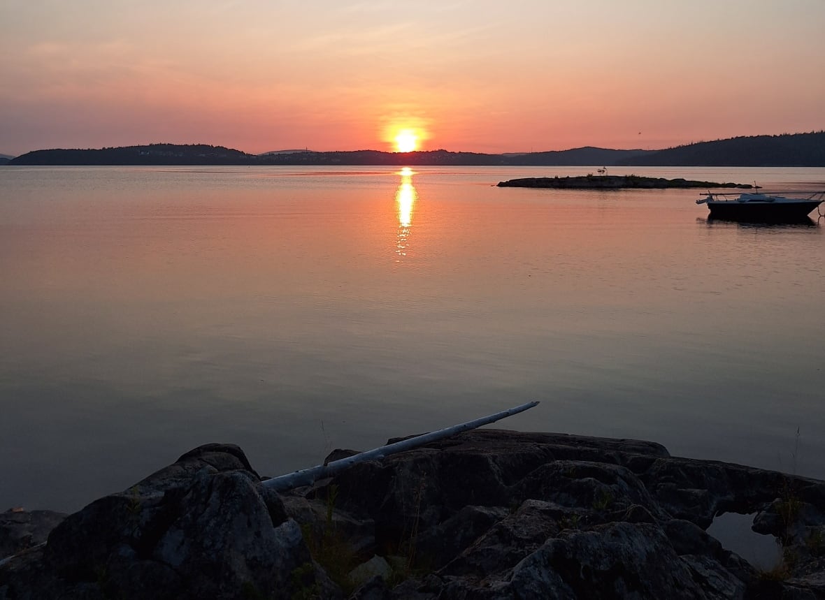 A sunrise over a still body of water